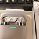 Bílá nabíjecí pouzdro s bezdrátovými sluchátky v uších. Na obou sluchátkách je viditelný nápis Bowers & Wilkins. Vnitřní strana víčka pouzdra obsahuj…