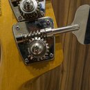 Detail hlavy žluté kytary s dvěma chromovanými ladicími mechanismy. Na ozubeném kole spodního mechanismu je vyryto „GOTOH“ a „MADE IN JAPAN“. Povrchy…