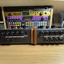 Dvě moduly s dřevěnými bočními panely umístěné vedle sebe. Levý modul má nápisy AUDIO IN, CUTOFF (pod nimi AUDIO OUT a ENV OUT), MIX, RES. a AMOUNT,…