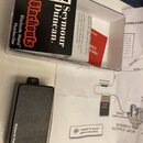 Na fotografii je černý obdélníkový modul s nápisem Seymour Duncan a doprovodný papírový návod se schématem zapojení. Modul je umístěn vedle průhledné…