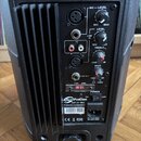 Zadní panel černého aktivního reproduktoru s chladičem. Na panelu jsou vstupy MIC, LINE IN (jack a RCA), výstup LINE OUT, ovladače MIC-LEVEL, LEVEL,…