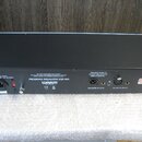 Zadní strana černého rackového zařízení s nápisem PROGRAM EQUALIZER EQP-WA a logem WARM AUDIO. Jsou zde vidět konektory pro napájení AC Power 115/230…