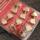 Sada šesti zlatých ladicích kol v originálním plastovém obalu s červeným podkladem. Na obalu je vidět nápis OVER, NEST MACHINE HEADS a texty LOCKS AU…