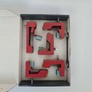 V krabičce s pěnovou výplní jsou umístěny čtyři červené kovové svorky v různých tvarech. Každá svorka má na stěnách nalepené světle modré ochranné po…