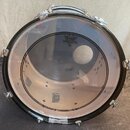 Černý basový buben s průhledným předním koženem. Na koženě je umístěno logo REMO s nápisem WEATHERKING POWERSTROKE 3 BASS. Povrch koženu vykazuje zná…