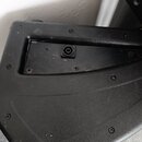 Detailní pohled na černý plastový nebo lakovaný povrch hudebního přístroje. V horní části je vidět zapuštěný konektor typu jack v černém plastovém rá…