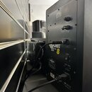 Zadní strana černého studiového monitoru značky KRK SYSTEMS. Na zadním panelu jsou vidět ovládací prvky pro HF LEVEL ADJUST a VOLUME, vstup BALANCED…