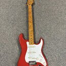 Červená elektrická kytara s bílým pickguardem a hnedým javorovým hmatníkem. Na hlavě je viditelné logo Squier. Kytara má tři snímače, pětistupňový př…