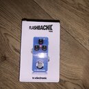 Bílá krabička s nápisem FLASHBACK MINI a logem tc electronic. Uvnitř je zobrazen modrý kytarový efekt s nápisy DELAY, F. BACK a LEVEL u ovládacích pr…