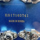 Záběr na zadní stranu modré kytarové hlavy s kovovými ladičkami. Uprostřed je zlatým písmem nápis KS17103741 a pod ním MADE IN KOREA. Povrch je leskl…
