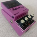 Fialový kytarový efekt s černým ovládacím panelem a gumovou podložkou. Na horní části je nápis Flanger BF-2 a šipky OUTPUT a INPUT. Ovládací panel ob…