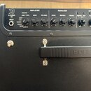 Detail horní části černého kytarového komba s ovládacím panelem. Na panelu jsou nápisy KATANA 50, INPUT a sekce AMPLIFIER (AMP TYPE, GAIN, VOLUME), E…