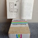 Fotografie zachycuje krabici a přiložený návod k efektu. Na krabici je nápis musitronics a MU-TRON III / musitronics / octave divider II spolu s bare…