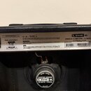 Zadní strana černého kytarového komba. Na horním štítku je bílý nápis LINE 6 a model SPIDER III 15 AMPLIFIER - 15 WATTS 1X8, dále U.S. PATENT NO. 5,7…