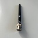 Na fotografii je černá anténa s kovovým konektorem stříbrné barvy. Na černém těle je bílé logo značky Sennheiser a nápis UKCA. Povrch antény i konekt…