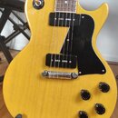 Žlutá elektrická kytara s tvarem singlecut a černým pickguardem. Nástroj má dva černá humbuckery, čtyři ovládací knofíky a přepínač s nápisy RHYTHM a…