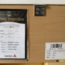 Fotografie zachycuje detail vnitřní části nástroje s připevněným certifikátem „Factory Inspection“ a identifikační nálepkou. Na dokumentu i na nálepc…