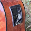 Detail na vestavěný předzesilovač v boční straně akustické kytary s dřevěným povrchem. Černý plastový panel nese bílý nápis ARTEC a ovládací prvky s…