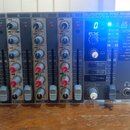 Rackový mixážní pult stříbrné barvy s modrými ovládacími prvky. Na horní části je nápis EURORACK PRO RX1202FX a pod ním text ULTRA LOW-NOISE DESIGN 1…
