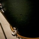 Detailní záběr na černý povrch bubnu s chromovaným hardwarem. Povrch vykazuje drobné škrábance a v centru je viditelný malý odřap nebo důlek. Žádné z…