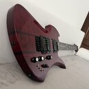 Elektrická kytara s červeným lakem a viditnou strukturou dřeva. Nástroj má dva černé humbuckery, černý most a čtyři ovládací knofíky. Na spodní části…
