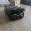 Černý expresní pedál značky BOSS, model EV-1-WL. Na zadním panelu jsou viditelné konektory a nápisy: POWER (s přepínačem OFF/ON), DC IN (pod kterým j…