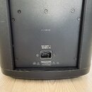 Zadní strana černého reproduktoru s nápisem L1 PRO8. U napájecího konektoru je uveden text 100-240V ~ 50/60Hz 1A a varovný štítek s nápisem CAUTION.…