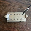 Kytarový snímač s kovovým krytem stříbrné barvy. Na povrchu je vyražen nápis DIMARZIO PICKUPS MADE IN U.S.A. a ručně napsaný text Dominion bridge. Na…