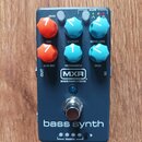 Tmavě modrý efekt pedál s nápisem bass synth. Na horní části jsou šestihranné ovladače v oranžové a tyrkysové barvě s popisky VOICE, CUTOFF, ENVELOPE…