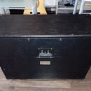 Zadní strana černého reproduktorového boxu potaženého texturovaným vinylen. Uprostřed se nachází ovládací panel s dvěma přepínači a nápisy "MIC. STUD…