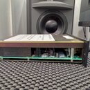 Fotografie znázorňuje vnitřní součásti elektronického zařízení bez krycího krytu. Je vidět zelená základní deska s osazenými kondenzátory, rezistory…