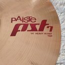 Detailní pohled na mosazný činel s koncentrickým broušením povrchu. Na čineli je červený nápis pAiste a pod ním stylizovaný červený nápis pst. Dole j…