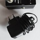 Černý kytarový ladič s nápisy MiniTune a Vivlex, přepínačem BYPASS a konektory OUTPUT a INPUT. Na pravé straně jsou značky b, c a # s kontrolkami a n…