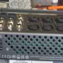 Zadní strana šedého elektronického zařízení s nápisem ALLEN&HEATH. Jsou zde viditelné různé konektory, včetně několika XLR a jacků, přepínač OFF/ON a…