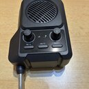 Černý kompaktní zesilovač s integrovaným reproduktorem a 6,35mm jack konektorem. Na přední straně jsou dva otočné ovladače, tři tlačítka s nápisy 14/…