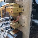 Fotografie zachycuje vnitřek elektronického zařízení, pravděpodobně zesilovače, s kovovým šasi. Jsou zde vidět dvě elektronické lampy a dva žluté tra…