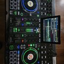Černý DJ set složený ze dvou kontrolérů a centrálního mixeru s integrovaným displejem. Na spodním kontroléru je viditelný nápis PRIME 4 a na horním D…