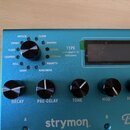Modrý efekt pedál s nápisy strymon a BigSky. Na horní části je otočný přepínač typu efektu s označením TYPE a okolními názvy: IMPULSE, CLOUD, SHIMMER…