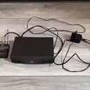 Černý bezdrátový systém složený z přijímače, vysílače a napájecího adaptéru. Na přijímači je nápis PERCEPTION wireless a SR-45, na vysílači nápisy PE…