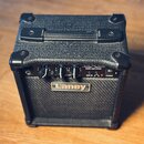 Černý basový kombo zesilovač s texturovaným povrchem a plastovými rohy. Na předním panelu je nápis BASS AMPLIFIER a model LX10B, v dolní části se nac…