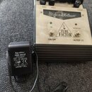 Kytarový efekt v bílo-černém provedení s nápisem TUBE FACTOR. Na horní části jsou tři černé ovratové knoflíky s popisky DRIVE, OUT PUT a VOICING. Na…