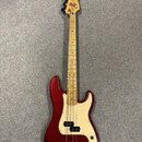 Třístrunná elektrická basová kytara s vínovým lakovaným tělem a krčkem z jasného dřeva. Na hlavě je viditelné logo Fender. Bílý pickguard obsahuje dv…