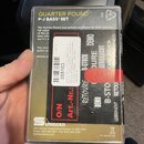 Fotografie znázorňuje originální krabičku od sady snímačů. Na obalu je nápis QUARTER POUND™ P-J BASS® SET a logo Duncan. Přes balení je nalepena bílá…