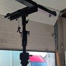 Černý kovový stativ s teleskopickým ramenem v pravém úhlu. Na konstrukci nejsou viditelné žádné značky, loga ani nápisy. Povrch je matně černý a vyka…