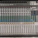 Stříbrný mixážní pult s nápisem Signature 22 MULTITRACK a logem Soundcraft v pravém horním rohu. Zařízení obsahuje numerous faders, potenciometry v b…