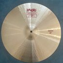 Kruhový činel z kovového materiálu s viditelným broušením. Na povrchu je červenobílé logo Paiste 2002 a nápisy TRADE MARK, MADE IN SWITZERLAND. V pra…