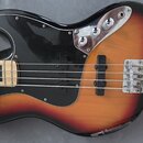 Detail korpusu elektrické basové kytary v barevném přechodu od žluté přes červenou k černé. Nástroj má černý pickguard, dva černá snímače a chromovan…