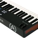 Černý MIDI kontrolér s klávesnicí a modrými podsvícenými pady. Na boku je bílý nápis ARTURIA a logo ve tvaru stylizedovaného písmene A v kruhu. V pra…