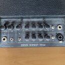 Zadní panel černého komba s nápisem PHIL JONES BASS. Panel obsahuje řadu otočných ovladačů s popisky MASTERVOE, LEVEL, TREBLE, MID, BASS a INPUT LEVE…
