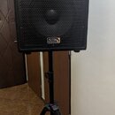 Černý reproduktor s kovovou mřížkou umístěný na černém stativu. Na spodní části reproduktoru je nápis Soundking a stejný nápis Soundking se nachází i…